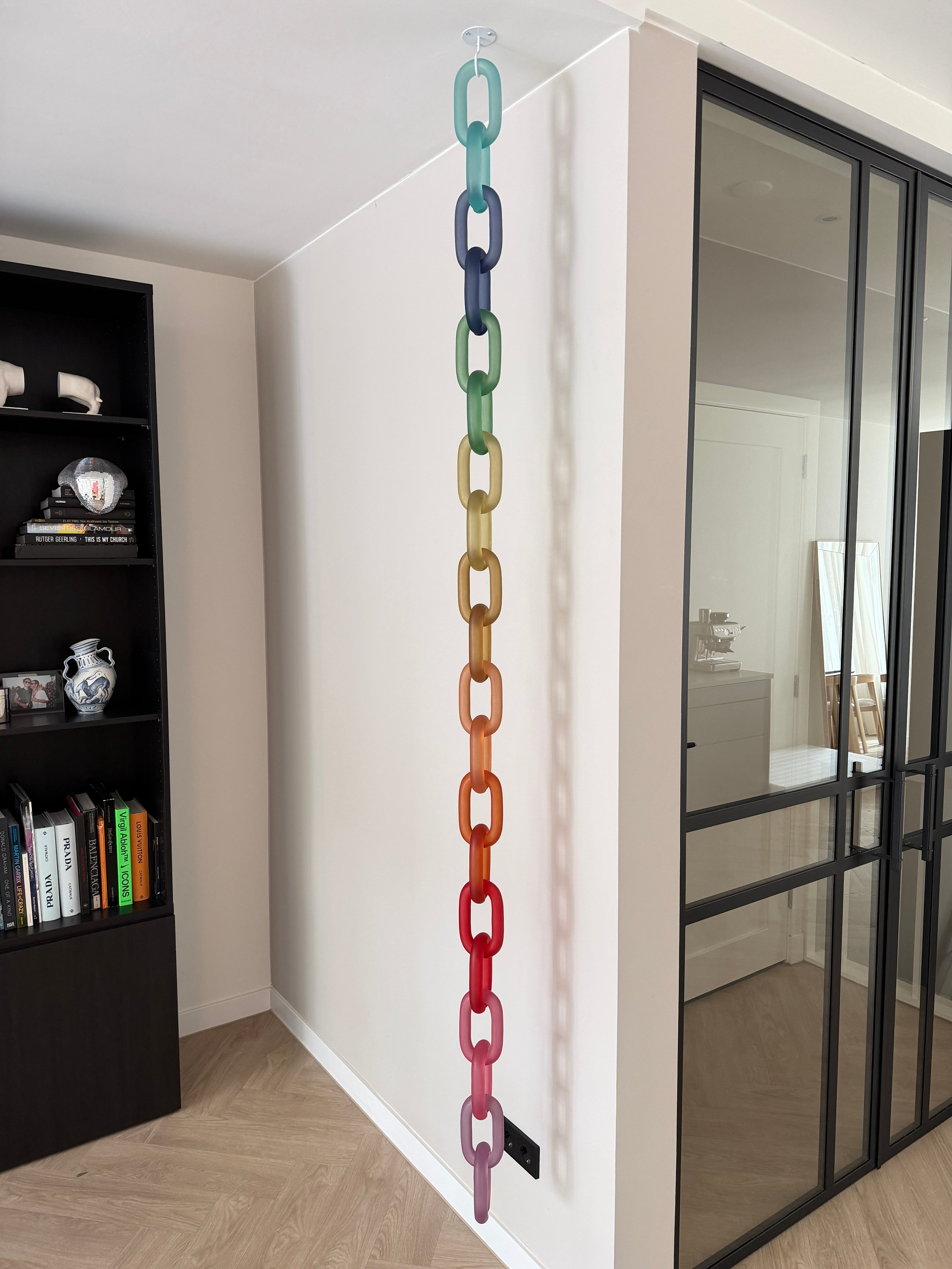 Colorful acrylic Infinity Links wall installation with rainbow tones, hanging as sculptural wall art.