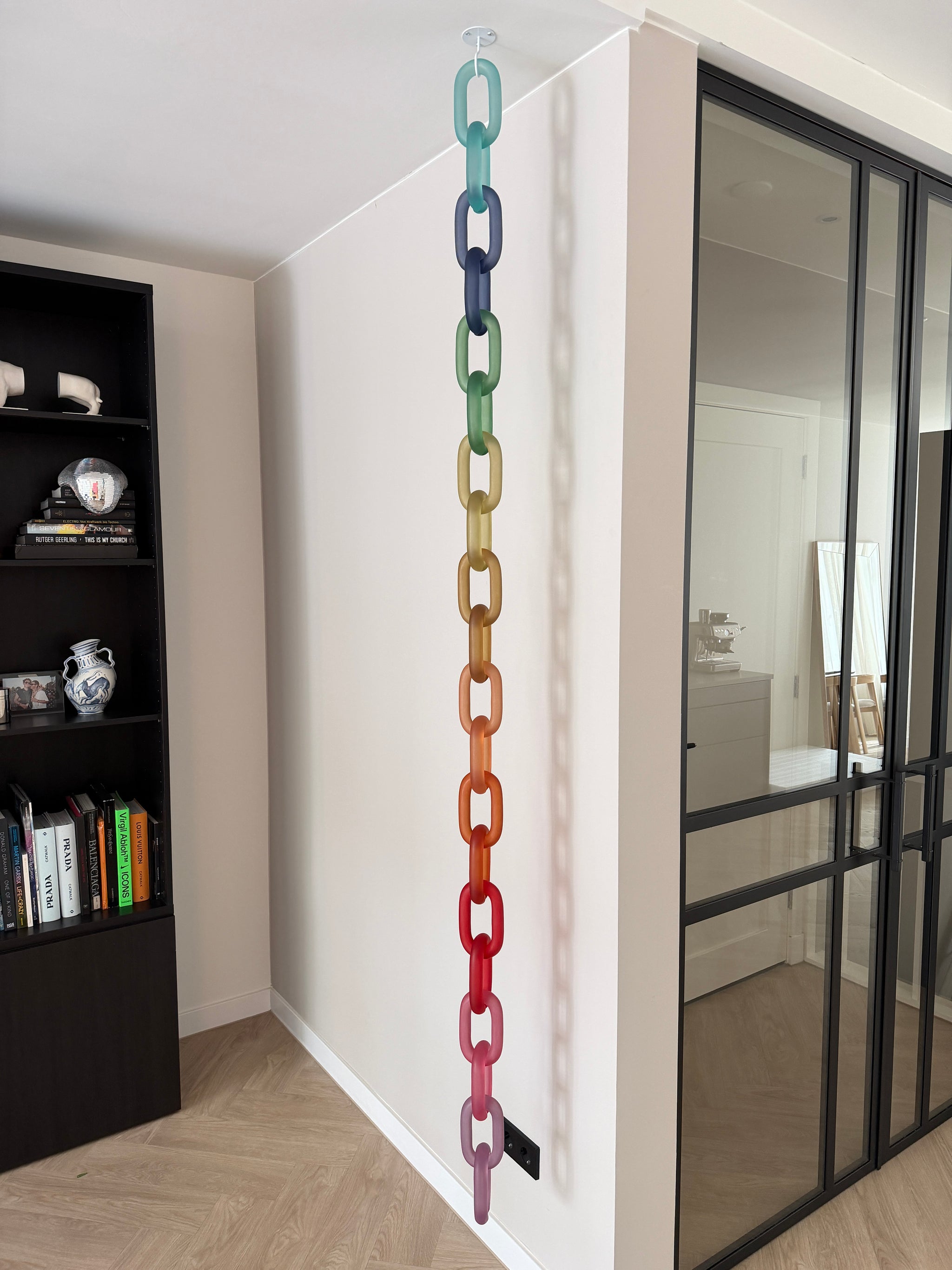 Colorful acrylic Infinity Links wall installation with rainbow tones, hanging as sculptural wall art.