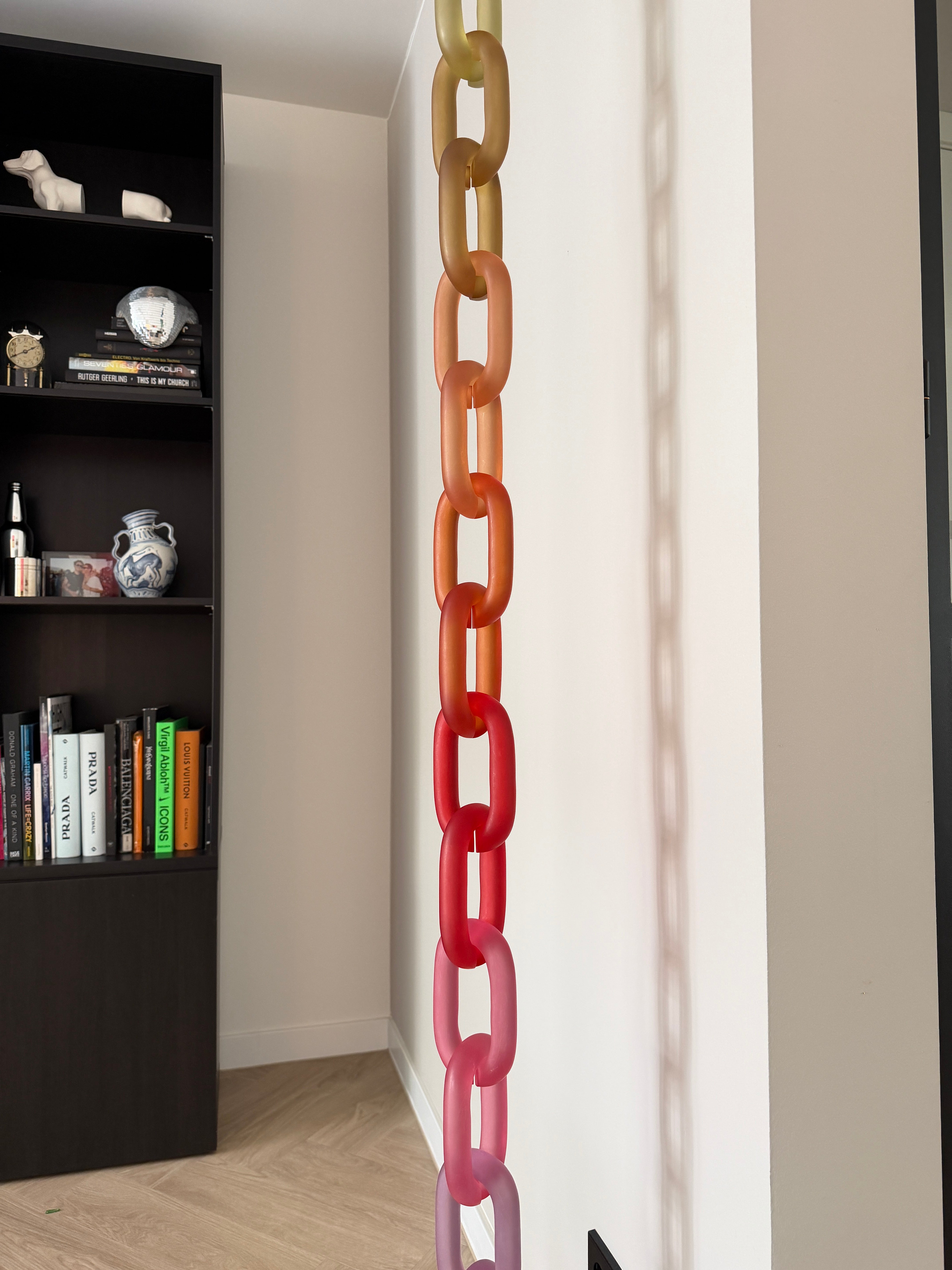 Colorful acrylic Infinity Links wall installation with rainbow tones, hanging as sculptural wall art.