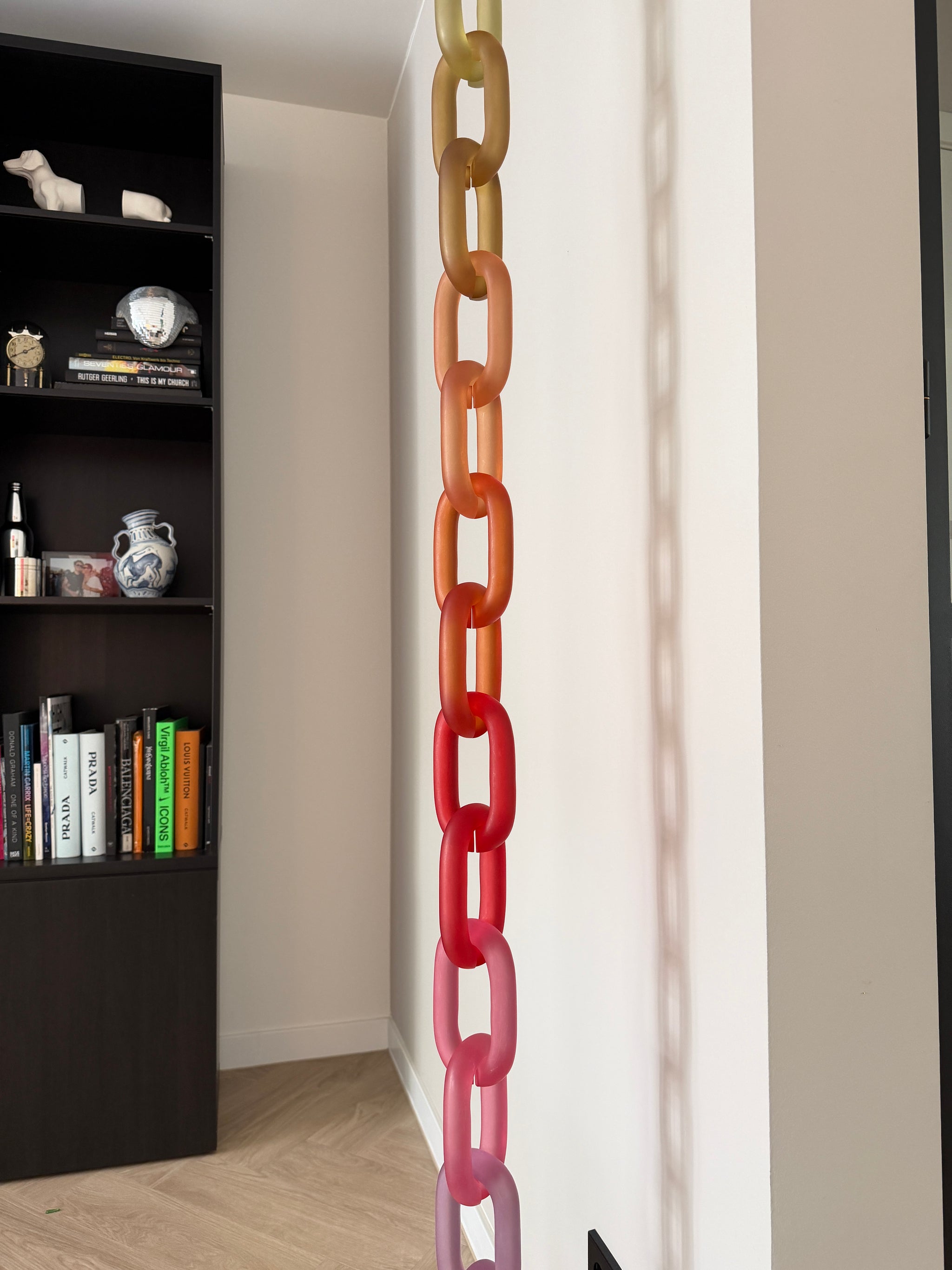 Colorful acrylic Infinity Links wall installation with rainbow tones, hanging as sculptural wall art.