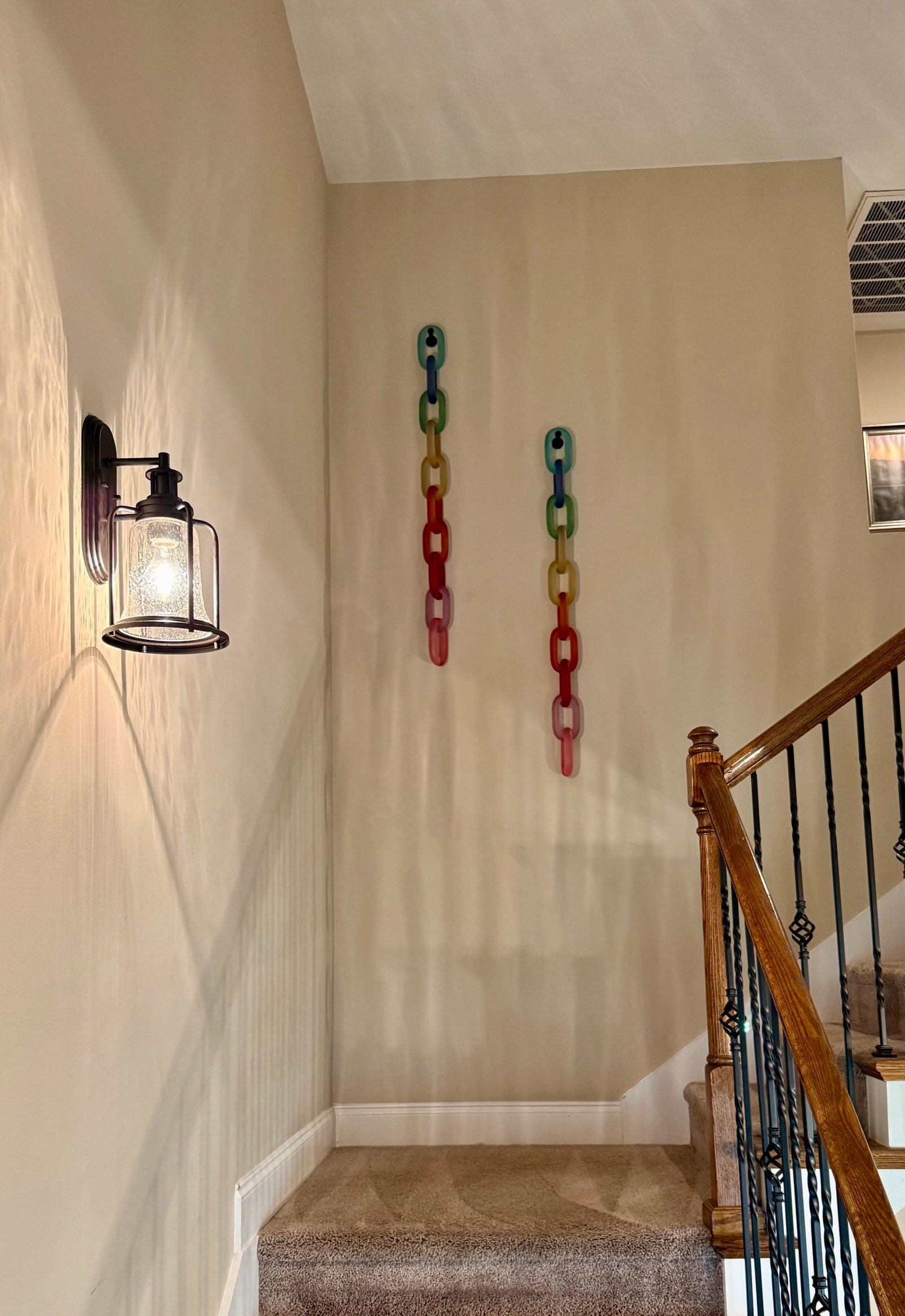 Colorful acrylic Infinity Links wall installation with rainbow tones, hanging as sculptural wall art.